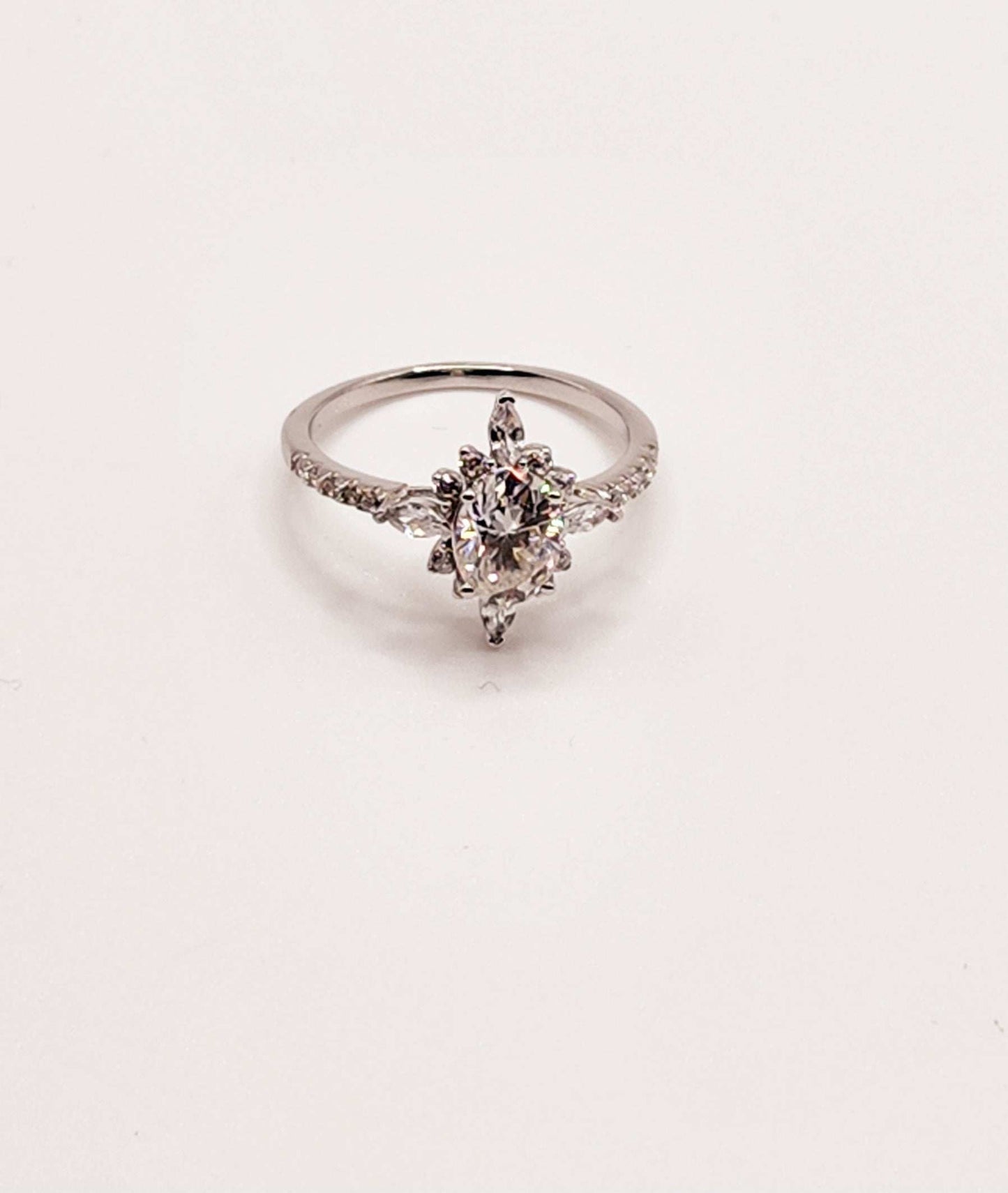 Multi shaped moissanite engagement ring in sterling silver with round cut gemstones.