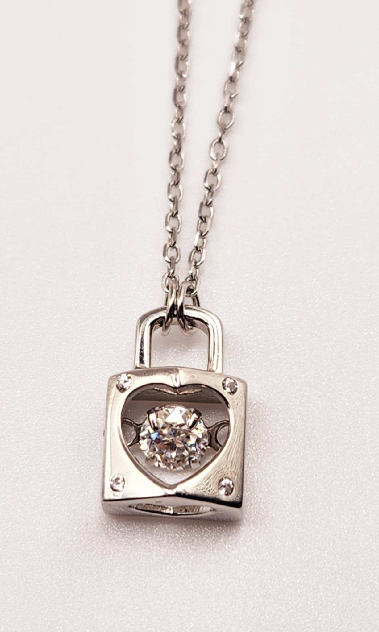 Dancing Gemstone Love Lock Pendant in sterling silver with a round cut gemstone.