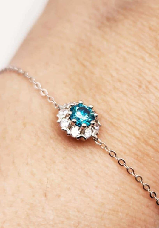 Elegant silver bracelet featuring a halo blue sapphire.