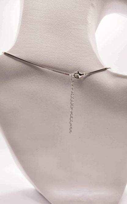 Open Cube Wrapped Solitaire Moissanite Necklace in Sterling Silver on display mannequin.