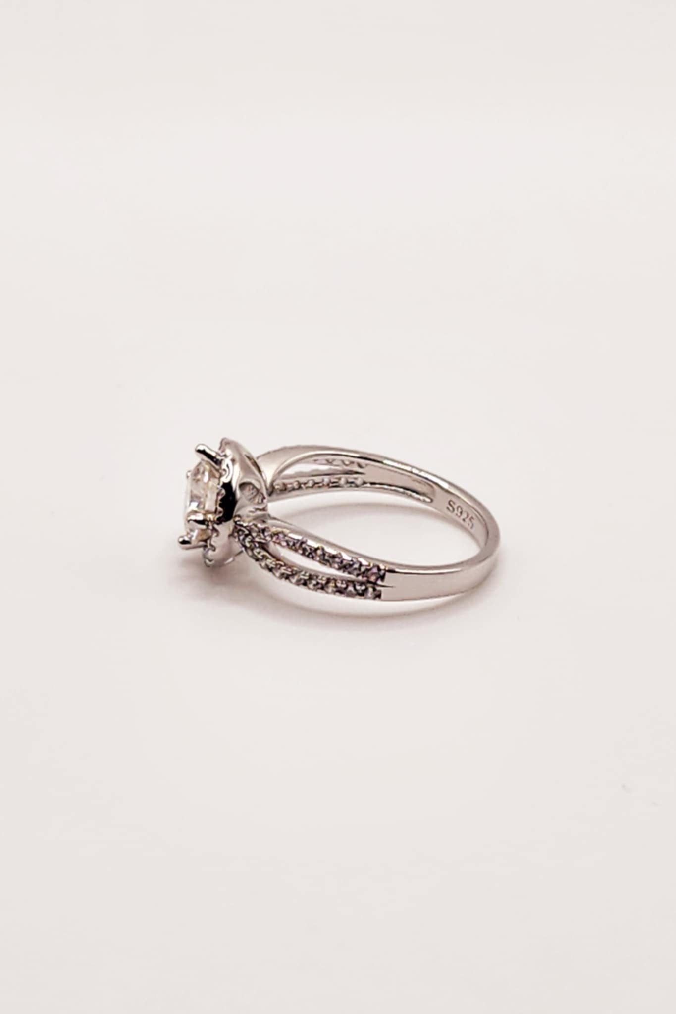 Round Moissanite Split Shank Halo Engagement Ring in 925 Sterling Silver with diamonds.